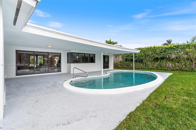 view of swimming pool with a yard and a patio area