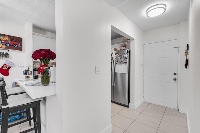 hallway with light tile patterned flooring and a textured ceiling