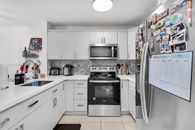 kitchen with sink, white cabinetry, backsplash, and appliances with stainless steel finishes