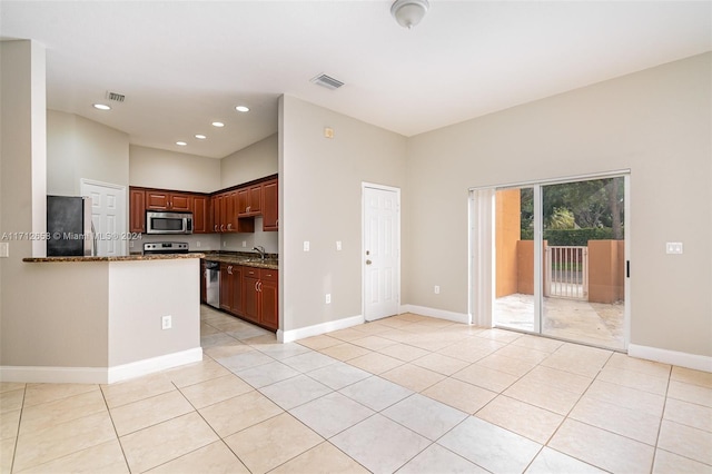 kitchen featuring light stone countertops, sink, light tile patterned floors, and stainless steel appliances