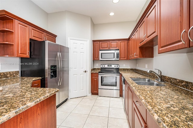 kitchen featuring dark stone counters, sink, light tile patterned floors, and stainless steel appliances