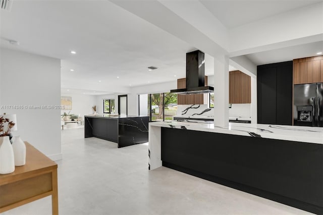 kitchen with a kitchen bar, island exhaust hood, and black refrigerator with ice dispenser