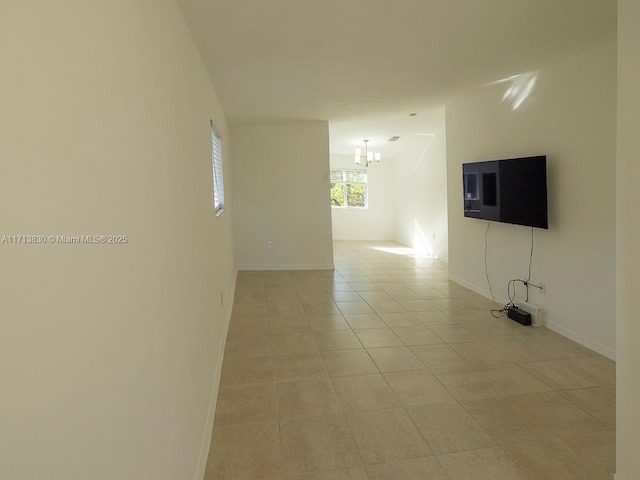 unfurnished living room with an inviting chandelier and light tile patterned floors