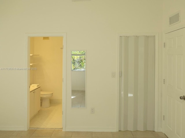 bathroom with toilet, tile patterned floors, and vanity