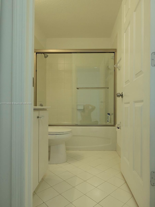 bathroom featuring tile patterned floors, enclosed tub / shower combo, and toilet