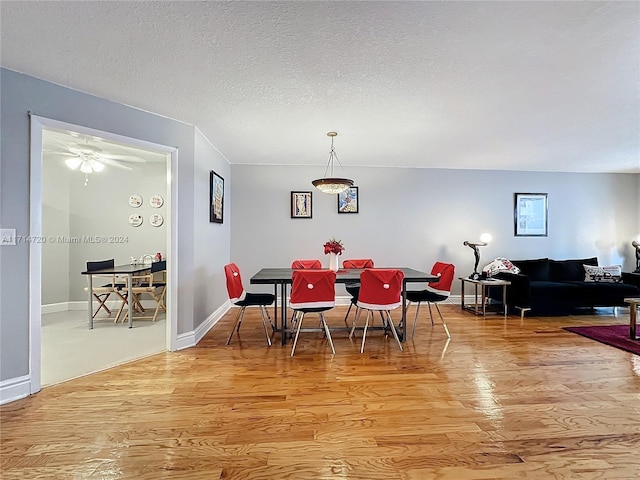 dining room with a textured ceiling, light hardwood / wood-style flooring, and ceiling fan