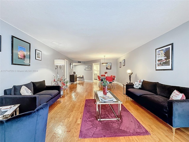 living room with a textured ceiling and light wood-type flooring