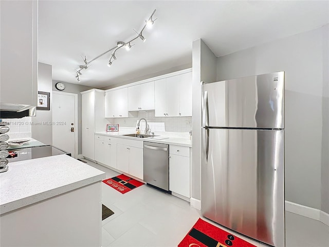 kitchen with decorative backsplash, sink, white cabinets, and stainless steel appliances