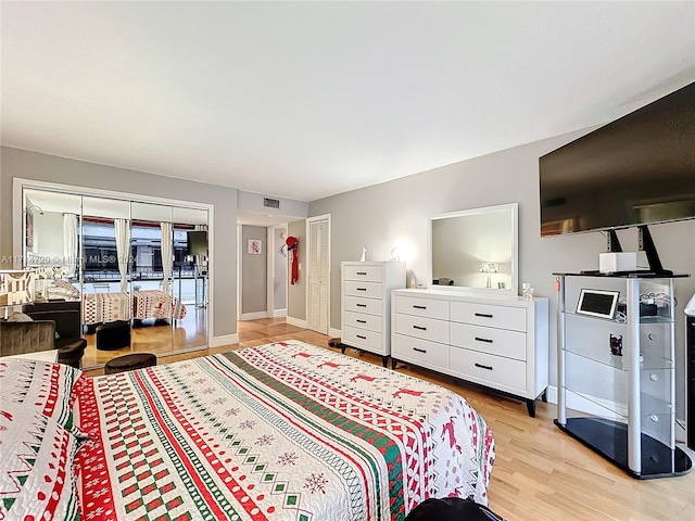 bedroom featuring access to exterior, light wood-type flooring, and a closet