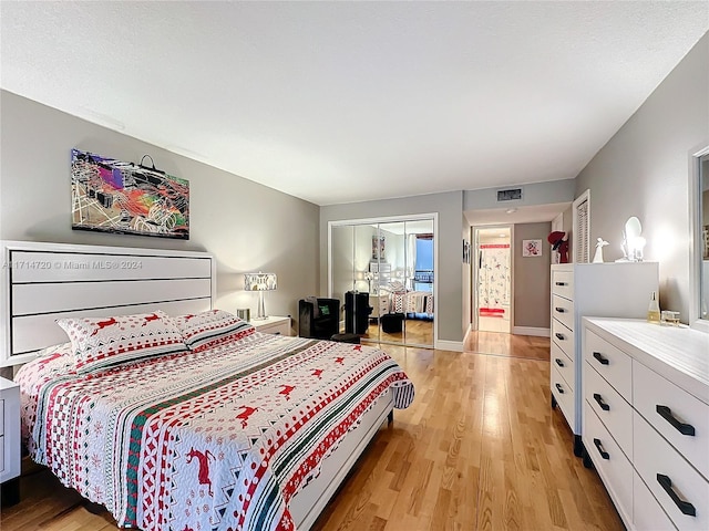 bedroom with light hardwood / wood-style floors and a closet