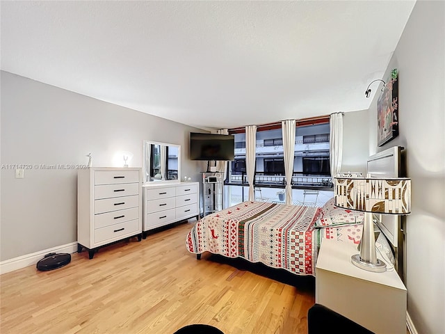 bedroom with access to exterior and light wood-type flooring