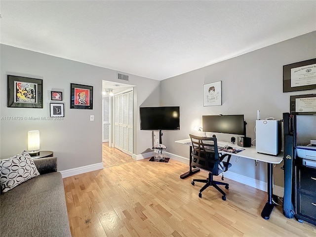 home office with light hardwood / wood-style floors