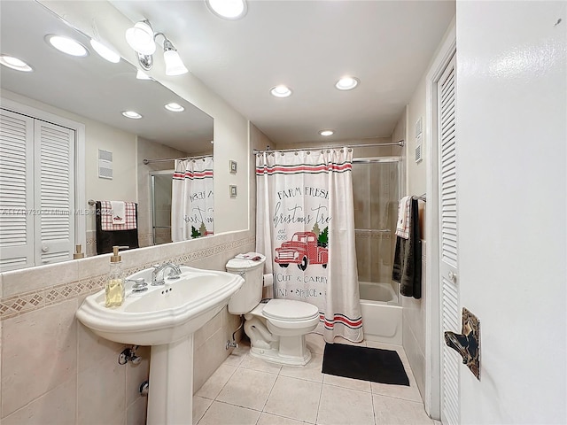 full bathroom with tile patterned floors, shower / tub combo with curtain, sink, tile walls, and toilet