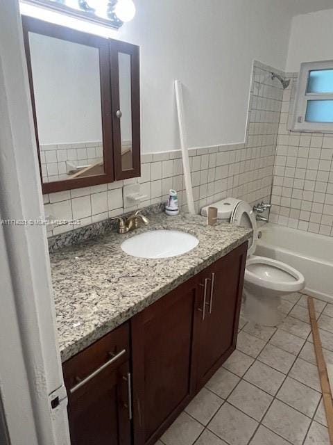 full bathroom featuring vanity, tiled shower / bath, tile patterned floors, and toilet