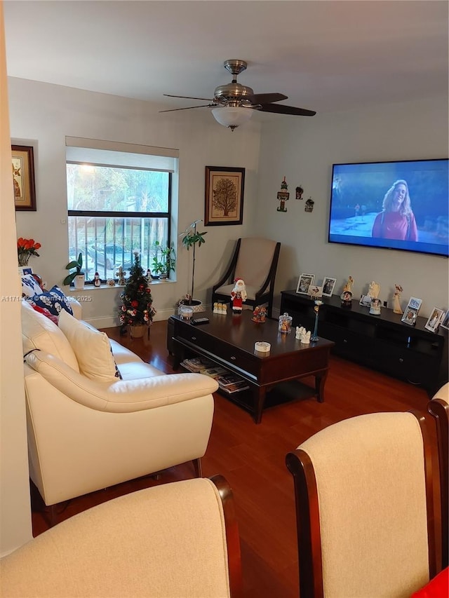 living room featuring ceiling fan and dark wood-type flooring