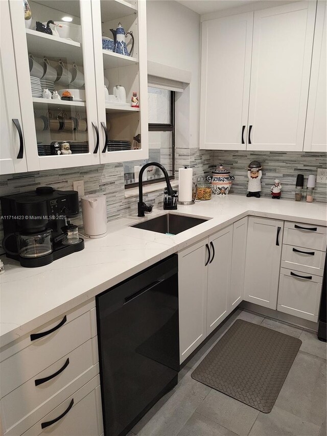 kitchen featuring white cabinets, dishwasher, decorative backsplash, sink, and light stone counters