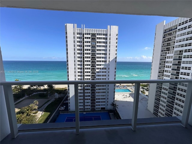 balcony featuring a water view and a beach view