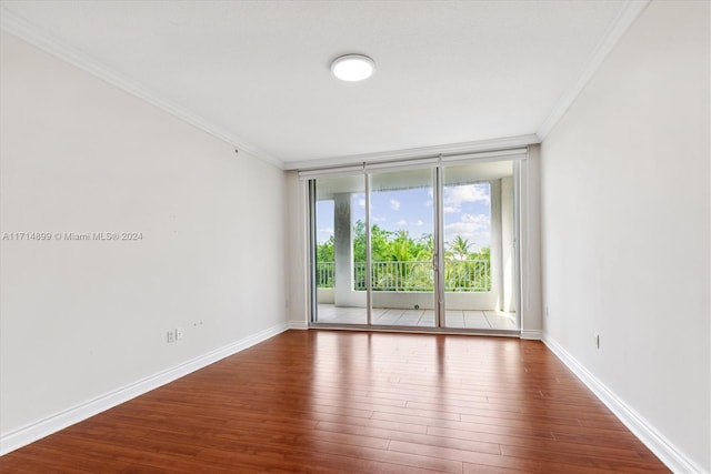 empty room featuring hardwood / wood-style floors, floor to ceiling windows, and ornamental molding