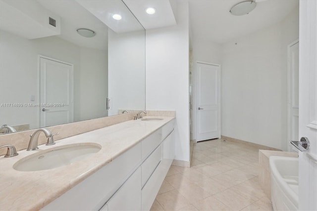 bathroom with tile patterned floors, vanity, and a bath