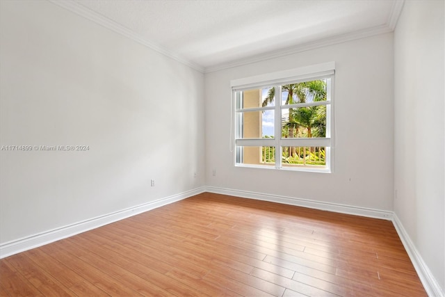 unfurnished room with ornamental molding and light wood-type flooring