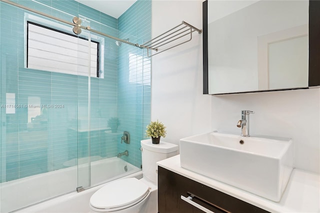 full bathroom with vanity, toilet, and bath / shower combo with glass door