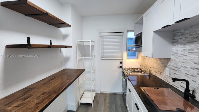 kitchen featuring backsplash, stainless steel appliances, sink, white cabinets, and butcher block countertops