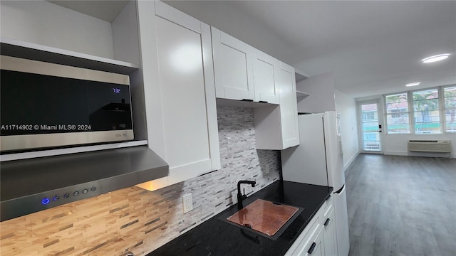 kitchen featuring tasteful backsplash, sink, white cabinets, and white fridge