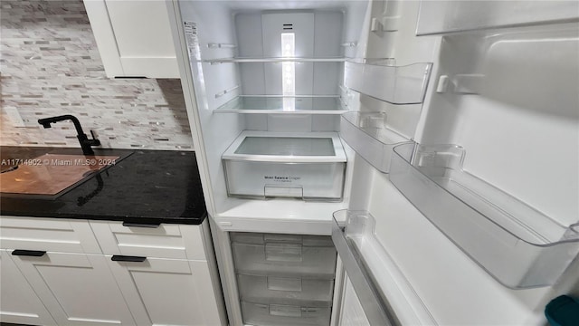 kitchen featuring backsplash and white cabinets