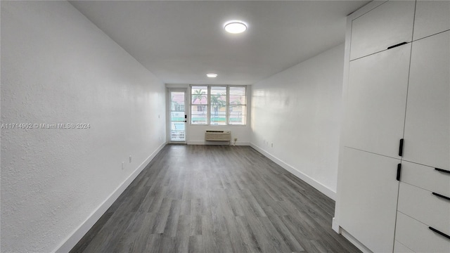 unfurnished room featuring hardwood / wood-style floors and a wall mounted AC