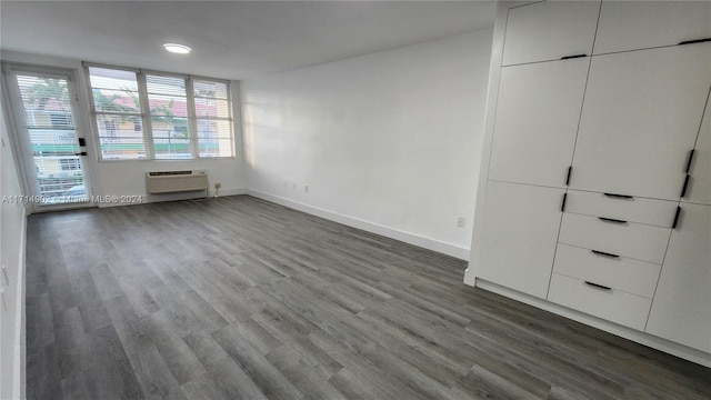 interior space with wood-type flooring and a wall unit AC