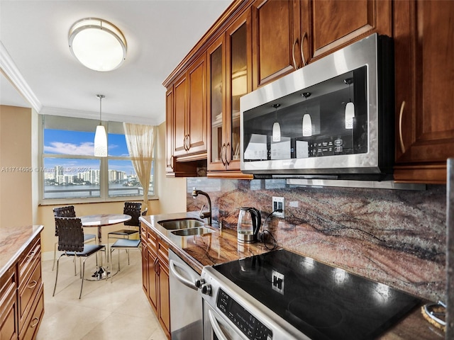 kitchen with light stone countertops, sink, stainless steel appliances, tasteful backsplash, and crown molding