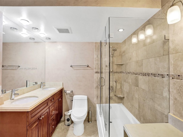 full bathroom with tile patterned floors, vanity, combined bath / shower with glass door, and toilet