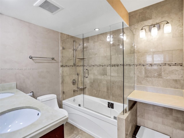 full bathroom with tile patterned floors, vanity, toilet, and bath / shower combo with glass door