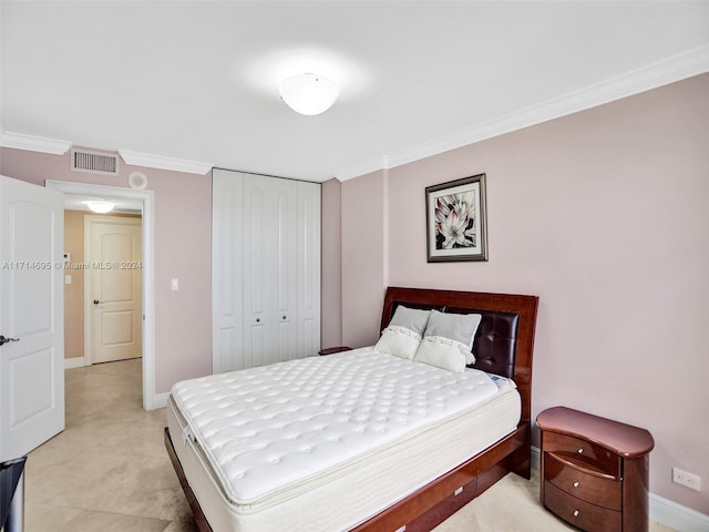 bedroom featuring crown molding and a closet