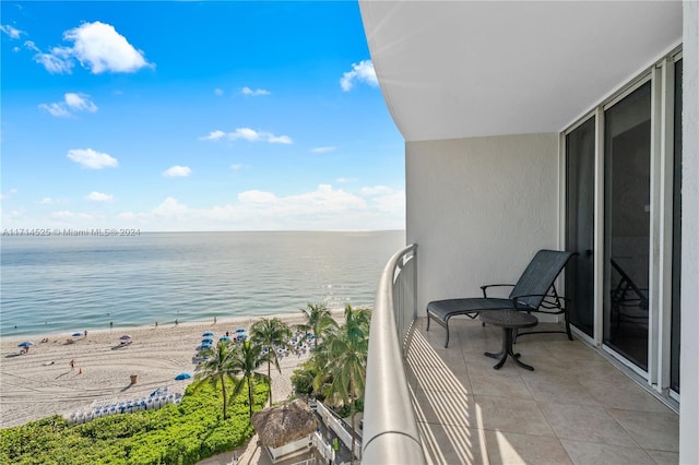 balcony featuring a water view and a beach view