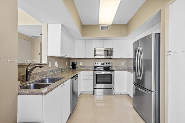 kitchen featuring white cabinets, sink, appliances with stainless steel finishes, and dark stone counters