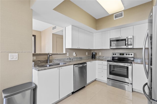 kitchen with white cabinetry, sink, light tile patterned floors, and appliances with stainless steel finishes