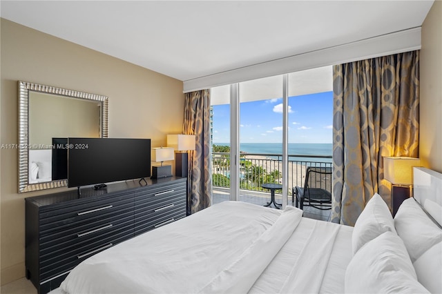 bedroom with access to outside and a wall of windows