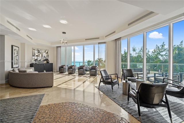 sunroom featuring a water view and a tray ceiling