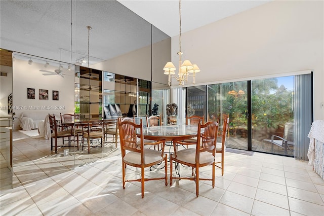 dining space featuring ceiling fan with notable chandelier and a textured ceiling