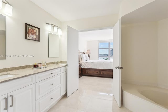 bathroom featuring tile patterned floors, a tub to relax in, and vanity