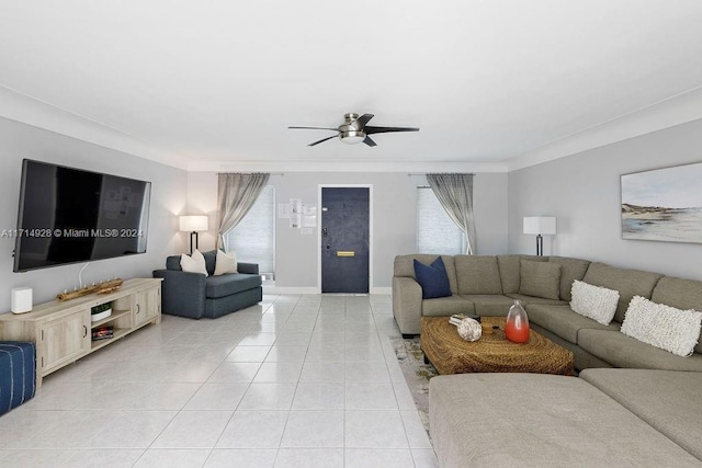 living room with ceiling fan, ornamental molding, and light tile patterned floors