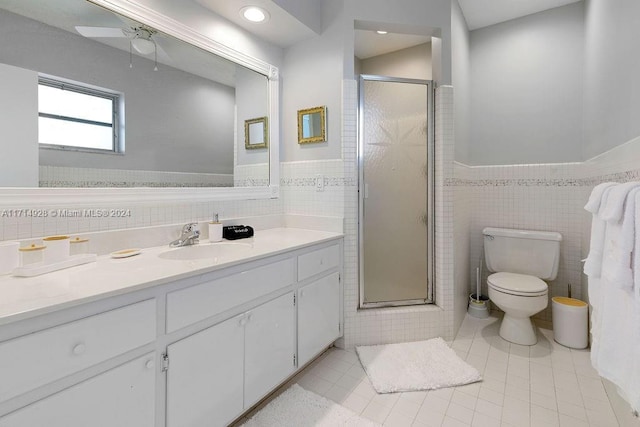 bathroom with an enclosed shower, vanity, tile walls, tile patterned flooring, and toilet