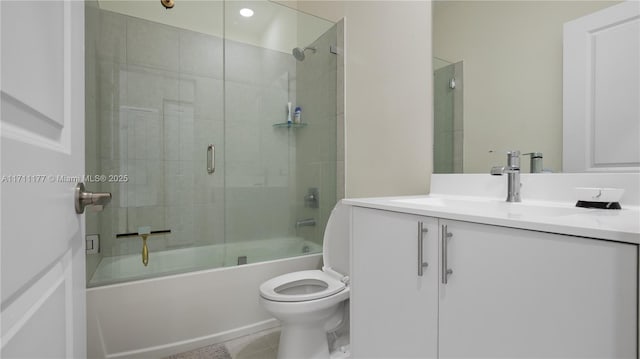 full bathroom featuring toilet, tile patterned floors, vanity, and bath / shower combo with glass door