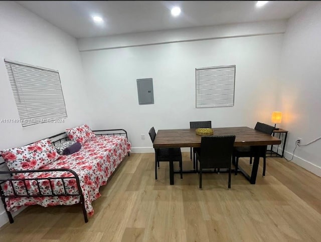 bedroom with electric panel and light hardwood / wood-style flooring