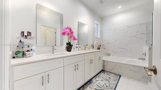 bathroom featuring vanity and tiled tub