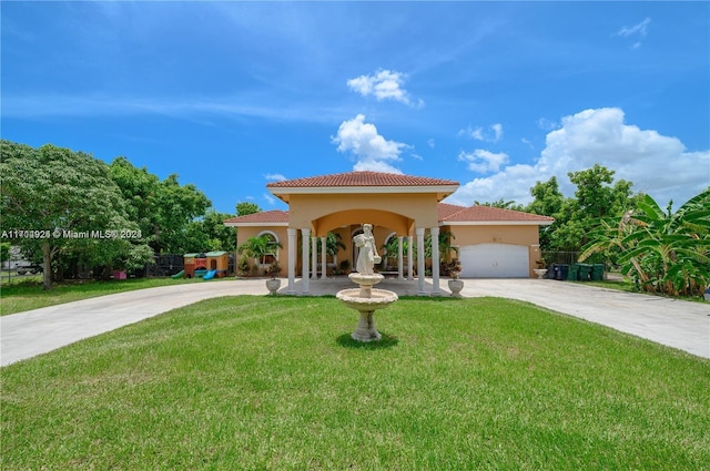 mediterranean / spanish-style house featuring a front lawn and a garage