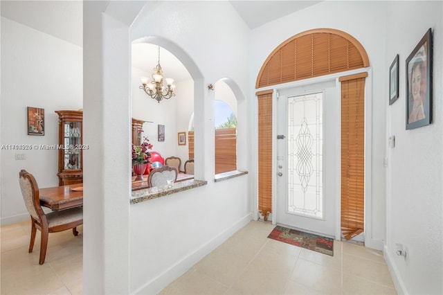 entrance foyer with light tile patterned floors and a notable chandelier