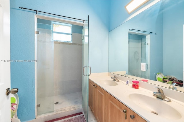 bathroom featuring tile patterned flooring, vanity, a shower with shower door, and a skylight