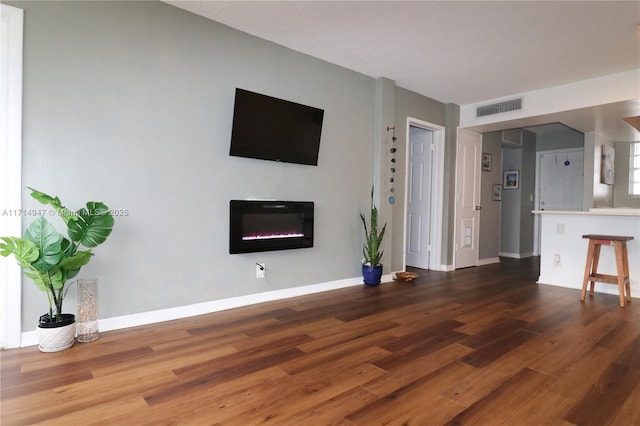 unfurnished living room with dark wood-type flooring